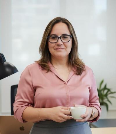 Imagen de María Oval, coach de crecimiento personal, con taza de café en la mano.